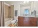 Bright bathroom with tiled shower, granite vanity, wood cabinets, and updated fixtures at 777 N Ashley Dr # 3009, Tampa, FL 33602