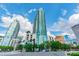 View of a modern condo tower with sleek architecture, surrounded by lush greenery and a vibrant city skyline at 777 N Ashley Dr # 3009, Tampa, FL 33602