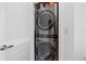 Modern laundry closet featuring a stacked washer and dryer unit with a white louvered door at 777 N Ashley Dr # 3009, Tampa, FL 33602