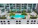 Aerial view of a rooftop pool with palm trees and lounge chairs between modern high-rise buildings at 777 N Ashley Dr # 3009, Tampa, FL 33602