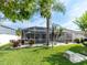 Well-maintained backyard showcasing the pool, decorative rocks, lush lawn, landscaping, and screened-in enclosure at 8508 Canterbury Lake Blvd, Tampa, FL 33619