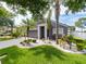 Landscaped front yard with palm trees and a charming home with a two-car garage at 8508 Canterbury Lake Blvd, Tampa, FL 33619