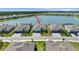 Stunning aerial view of a lakeside home featuring a two-car garage and lush landscaping in a desirable community at 8589 Saint Kitts Cir, Englewood, FL 34224