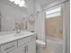 Elegant bathroom featuring a shower-tub combo, a vanity sink with modern fixtures and a large mirror at 8589 Saint Kitts Cir, Englewood, FL 34224