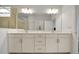 Bright bathroom with double vanity, large mirror and ample storage below at 8589 Saint Kitts Cir, Englewood, FL 34224