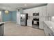 Well-equipped kitchen with stainless steel appliances, white cabinetry, and an adjacent dining area at 8589 Saint Kitts Cir, Englewood, FL 34224