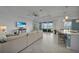 Spacious living room with sliding glass doors, fan, recessed lighting, and seamless flow to the kitchen and outdoor area at 8589 Saint Kitts Cir, Englewood, FL 34224