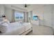 Bright bedroom featuring a tray ceiling, ceiling fan, and scenic views from a large window at 8589 Saint Kitts Cir, Englewood, FL 34224