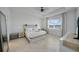 Bright main bedroom featuring a tray ceiling, ceiling fan, and scenic views from a large window at 8589 Saint Kitts Cir, Englewood, FL 34224