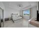 Bright main bedroom featuring a tray ceiling, ceiling fan, and scenic views from a large window at 8589 Saint Kitts Cir, Englewood, FL 34224