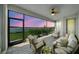 Screened patio with beautiful dusk views overlooking the lake and comfortable outdoor seating at 8589 Saint Kitts Cir, Englewood, FL 34224