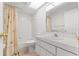 Clean, all white bathroom with tub/shower, modern vanity, and a large mirror at 9188 Rhett Ln, Weeki Wachee, FL 34613