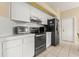 Updated kitchen featuring white cabinets, stainless steel appliances, and tile flooring at 9188 Rhett Ln, Weeki Wachee, FL 34613