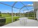 Screened lanai with a table overlooking a serene pond at 9188 Rhett Ln, Weeki Wachee, FL 34613