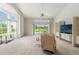 Open living room featuring a large sliding glass door to the patio and a comfortable recliner chair at 9188 Rhett Ln, Weeki Wachee, FL 34613