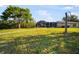 Back yard featuring a grass lawn, a palm tree, and a large screened enclosure at 925 Eagle Ln, Apollo Beach, FL 33572