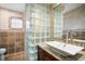 Bathroom featuring granite counters, wood cabinets, and a glass block shower enclosure at 925 Eagle Ln, Apollo Beach, FL 33572