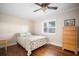Bedroom featuring hardwood floors, a ceiling fan, and a large window with shutters at 925 Eagle Ln, Apollo Beach, FL 33572