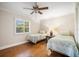 Charming bedroom featuring two twin beds, hardwood floors, and a ceiling fan at 925 Eagle Ln, Apollo Beach, FL 33572