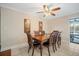 Traditional dining room featuring a wood table, elegant chairs, a ceiling fan, and access to the pool area at 925 Eagle Ln, Apollo Beach, FL 33572