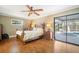 Bedroom with wood floors, ceiling fan, and sliding glass doors leading to the pool at 925 Eagle Ln, Apollo Beach, FL 33572