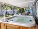 Backyard with a hot tub, and outdoor seating in a screened in porch with fan at 10233 N Valle Dr, Tampa, FL 33612