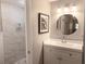 Bathroom with a large walk in shower with decorative tile and a single sink vanity with lighting at 10233 N Valle Dr, Tampa, FL 33612