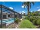 Relax in this backyard with a screened pool, lush lawn, and a cozy fire pit at 1028 Wyndham Way, Safety Harbor, FL 34695