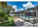 This backyard boasts a screened pool, brick patio, fire pit, and lush landscaping at 1028 Wyndham Way, Safety Harbor, FL 34695