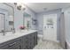 Bathroom features double vanity, tiled floor, and back door for easy outdoor access at 1028 Wyndham Way, Safety Harbor, FL 34695