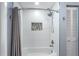 Clean bathroom showcasing tiled shower and bathtub with gray shower curtain at 1028 Wyndham Way, Safety Harbor, FL 34695