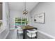 Dining area with wood table and view of the sparkling pool and outdoor space at 1028 Wyndham Way, Safety Harbor, FL 34695
