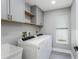 Bright laundry room features cabinets, shelves and gray flooring at 1028 Wyndham Way, Safety Harbor, FL 34695
