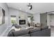Bright living room with a stone fireplace, ceiling fan, and a sliding barn door at 1028 Wyndham Way, Safety Harbor, FL 34695