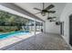Covered patio with ceiling fans, outdoor TV and access to screened pool area at 1028 Wyndham Way, Safety Harbor, FL 34695