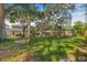 Expansive backyard featuring mature trees, a playset, and partial view of the home's exterior at 10819 Seminole N Dr, St Petersburg, FL 33708