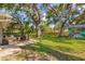 Large backyard with a patio, dining set, mature trees, and lots of space for recreation at 10819 Seminole N Dr, St Petersburg, FL 33708