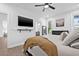 Spacious bedroom with a ceiling fan, flatscreen TV, and a view into a modern bathroom at 10819 Seminole N Dr, St Petersburg, FL 33708