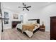 Bedroom with light walls, modern ceiling fan, windows and a large bed with wooden nightstand at 10819 Seminole N Dr, St Petersburg, FL 33708