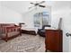 Bright bedroom with hardwood floors featuring a crib and rocking chair with a modern ceiling fan at 10819 Seminole N Dr, St Petersburg, FL 33708