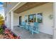 Inviting front porch with two blue Adirondack chairs, table and brick-trim columns at 10819 Seminole N Dr, St Petersburg, FL 33708