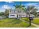 Charming two-story home with lush lawn, tall palm tree, and well-manicured landscaping at 10819 Seminole N Dr, St Petersburg, FL 33708