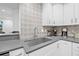 Modern kitchen features stainless steel sink, gray counters, and white cabinets at 10819 Seminole N Dr, St Petersburg, FL 33708