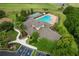 Aerial view of community clubhouse with swimming pool, tennis courts, and lush landscaping, showcasing amenities at 1129 Emerald Hill Way, Valrico, FL 33594