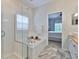 Bright bathroom featuring a soaking tub, glass shower, wood accents, and a view to the main bedroom at 1129 Emerald Hill Way, Valrico, FL 33594
