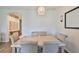 Bright dining room features a modern table and four cushioned chairs beneath a woven pendant light fixture at 1129 Emerald Hill Way, Valrico, FL 33594