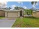 Charming single-story home featuring a well-maintained lawn, palm trees, and a two-car garage at 1129 Emerald Hill Way, Valrico, FL 33594