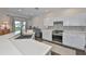 Charming kitchen features white cabinets, stainless steel appliances, and a tile backsplash at 1129 Emerald Hill Way, Valrico, FL 33594