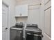 Laundry room with gray washer and dryer and cabinets for storage at 1129 Emerald Hill Way, Valrico, FL 33594
