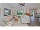 Comfortable living room with wood-look floors, ceiling fan, neutral decor and backyard views at 1129 Emerald Hill Way, Valrico, FL 33594